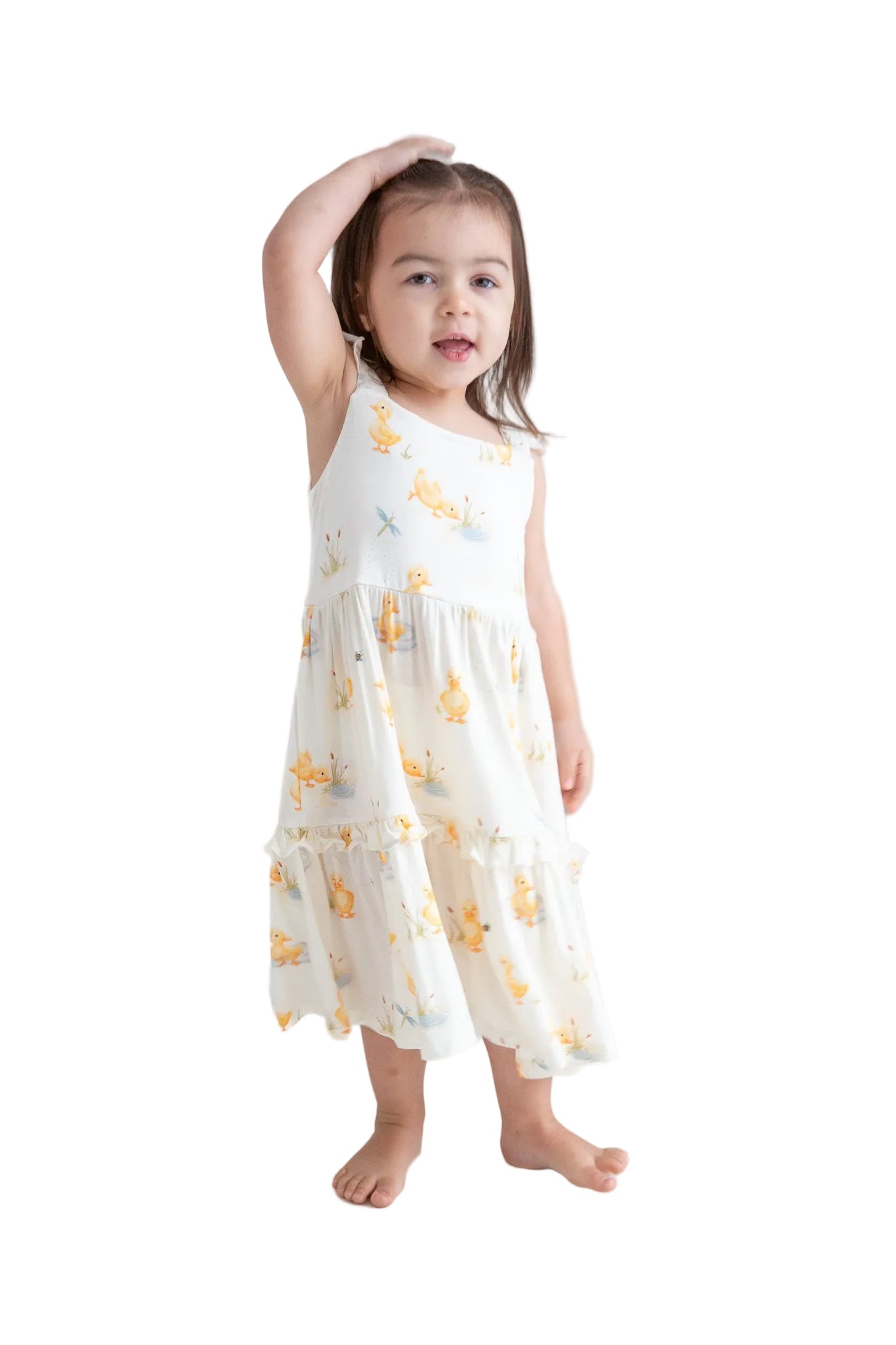 Young girl wearing a white dress with yellow floral patterns on a white background