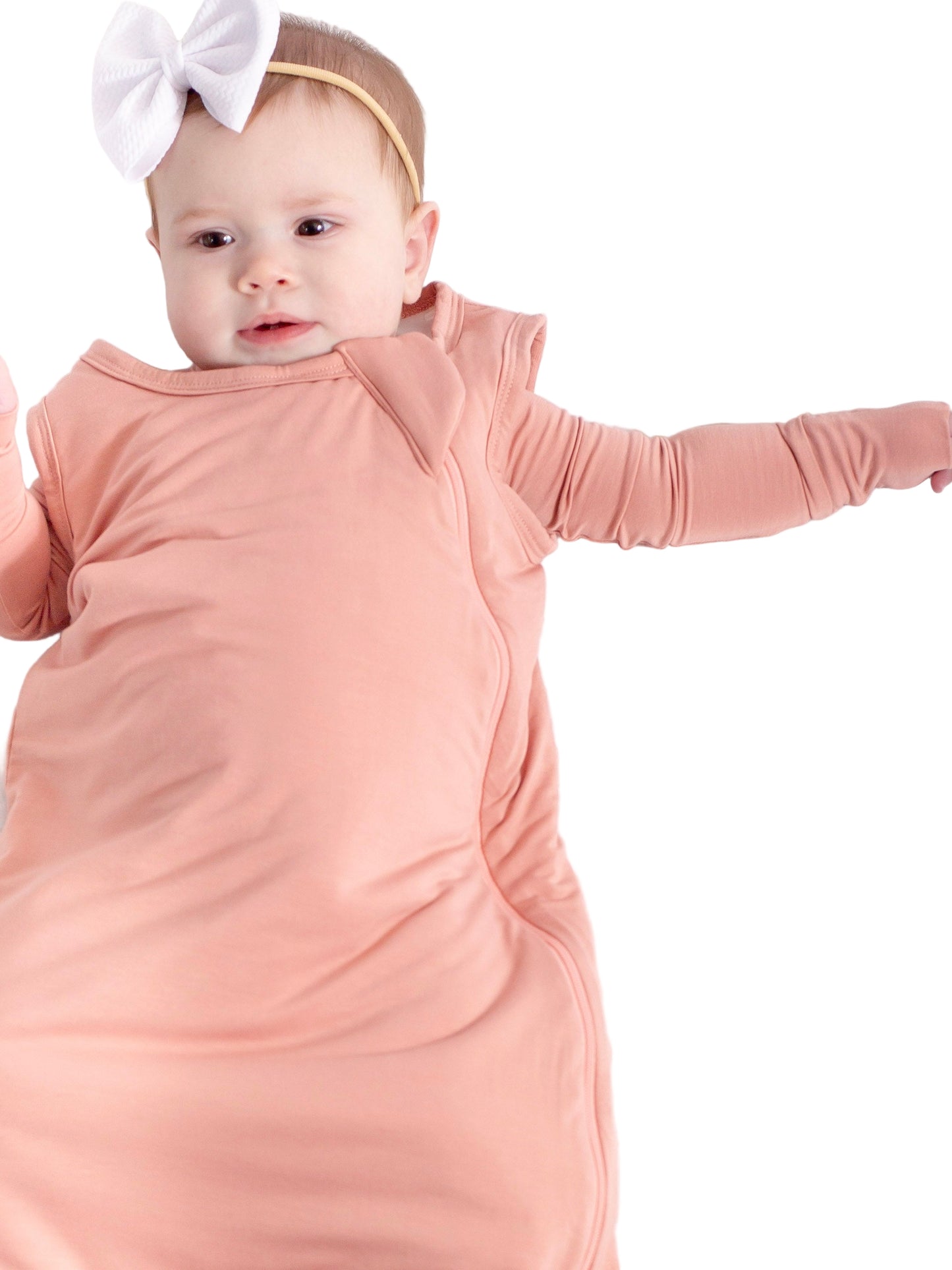 Baby in a pink swaddle with a white bow on a white background