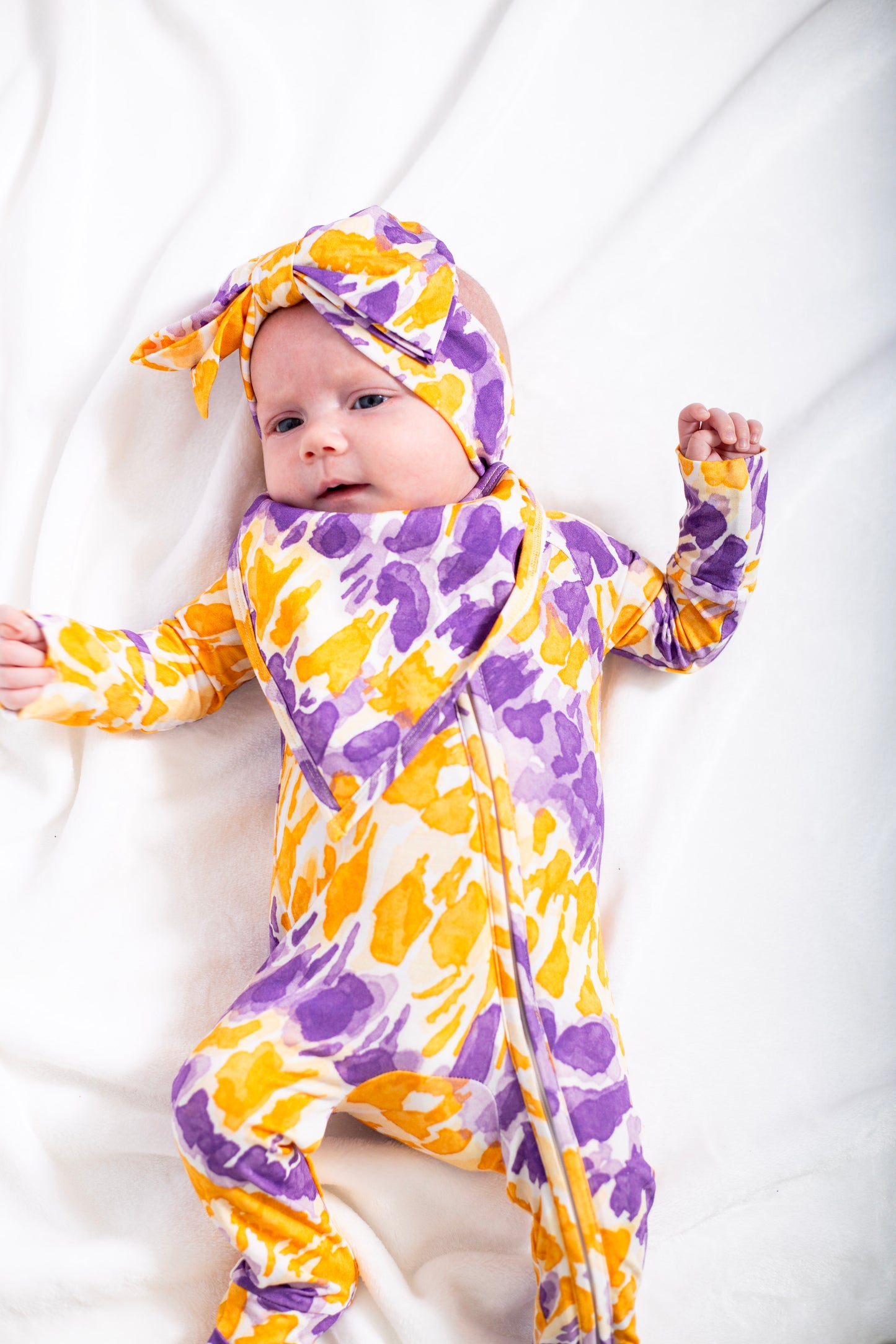 Baby wearing a colorful floral outfit on a white background