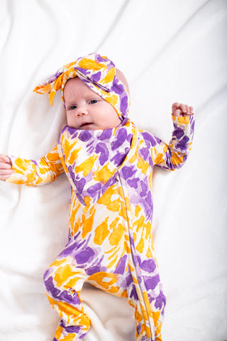 Baby wearing a colorful floral outfit on a white background