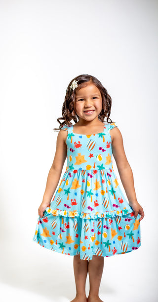 Young girl wearing a colorful dress with a fish pattern on a white background