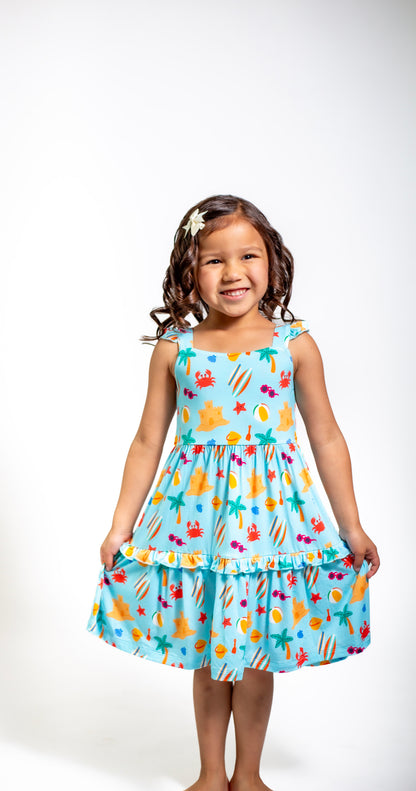 Young girl wearing a colorful dress with a fish pattern on a white background