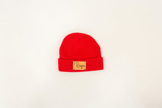 Red beanie with a gold label on a white background