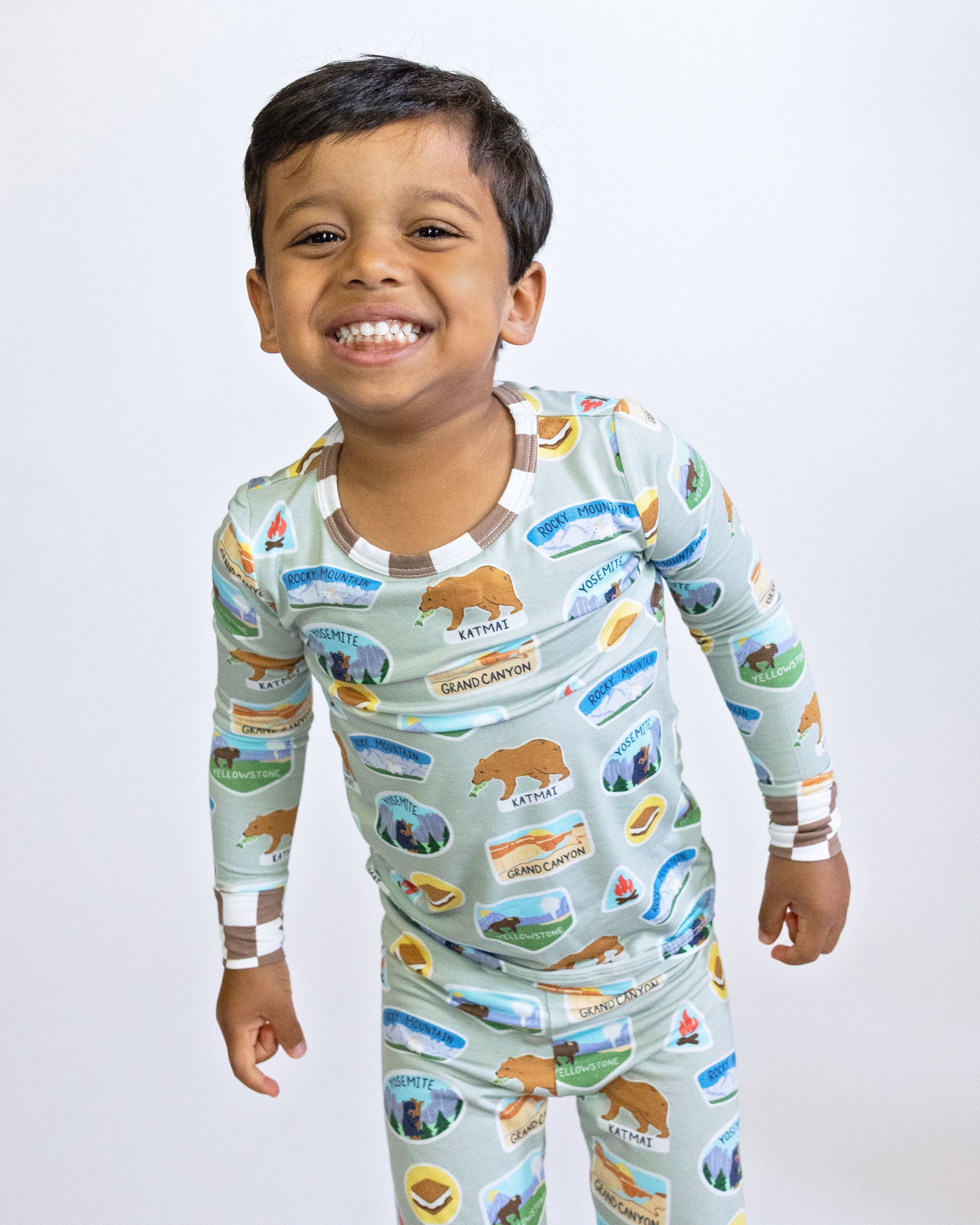Child wearing a pajama set with nature-themed design on a plain background