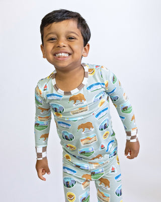 Child wearing a pajama set with nature-themed design on a plain background