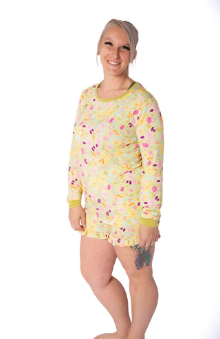 Woman wearing a yellow patterned nightshirt on a white background