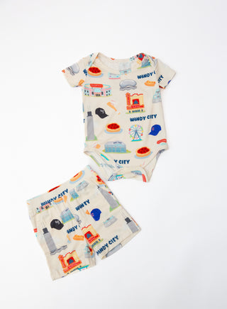 Baby onesie and bib with colorful city-themed design on a white background
