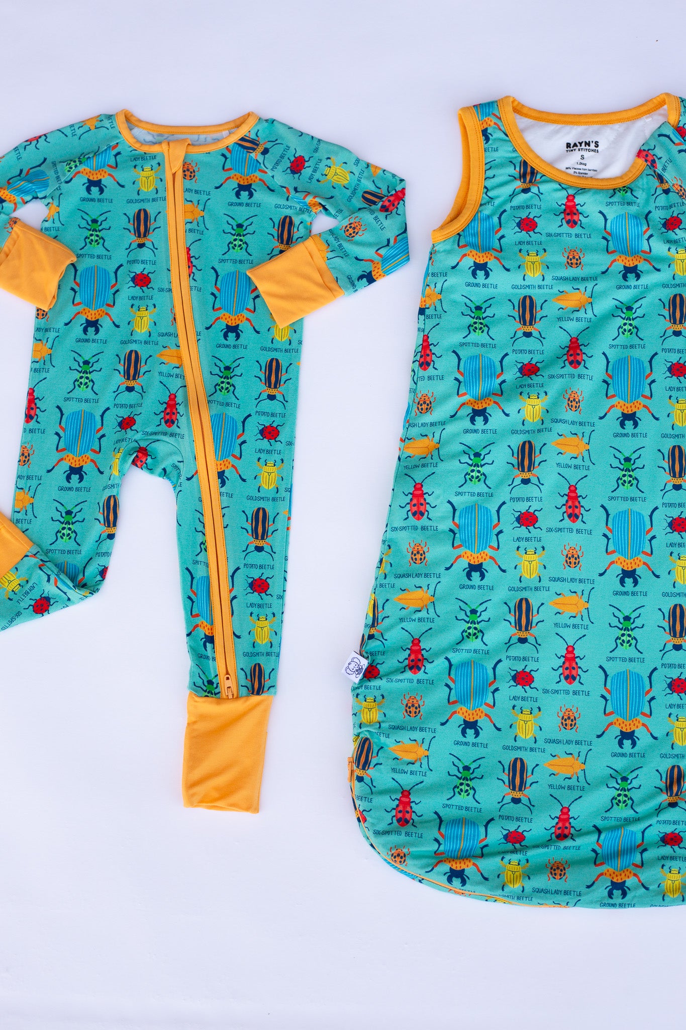 Two children's onesies with colorful insect pattern on a white background