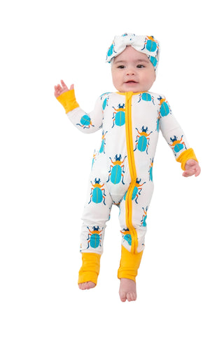 Baby wearing a colorful onesie with beetle design on a white background