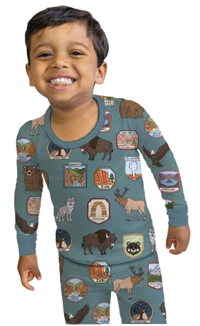 Child wearing a long-sleeve shirt with nature-themed designs on a blue background