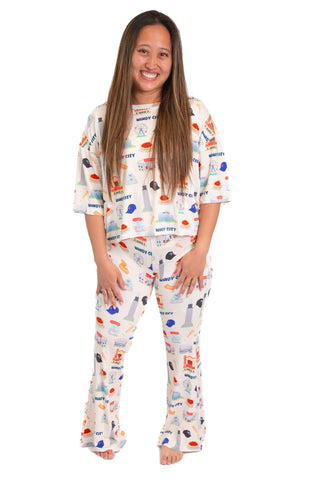 Woman wearing Windy City Chicago bamboo pajama set with oversized short sleeve top and flare pants featuring Chicago skyline artwork